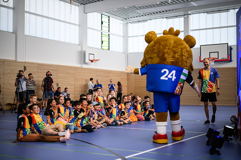 Das Maskottchen der Europameisterschaft 2024 informiert in einer Turnhalle