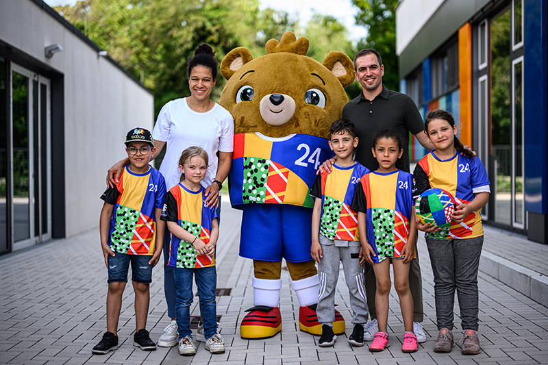 Maskottchen der Europameisterschaft 2024 auf einem Gruppenfoto mit Kindern
